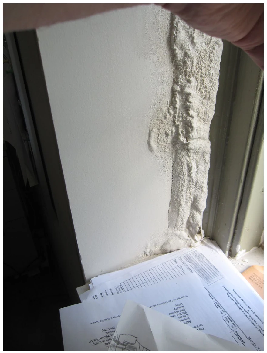 EPA-Leitfadenfoto regenbedingter Schäden an einer Innenoberfläche neben einem Fenster.